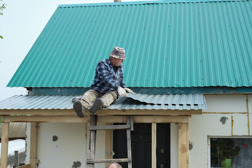 Roofing technician installing new shingles on a residential roof.